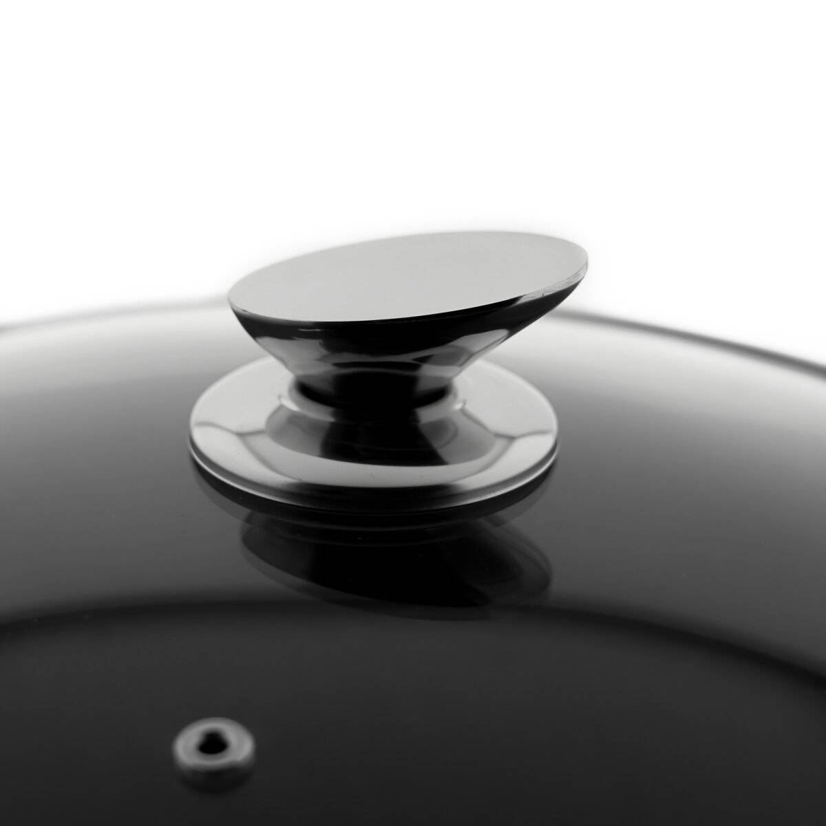 Eine Nahaufnahme einer glatten, glänzenden schwarzen Oberfläche mit einem Metallgriff, möglicherweise dem Deckel eines Kochtopfes oder einer Pfanne, die Licht reflektiert.