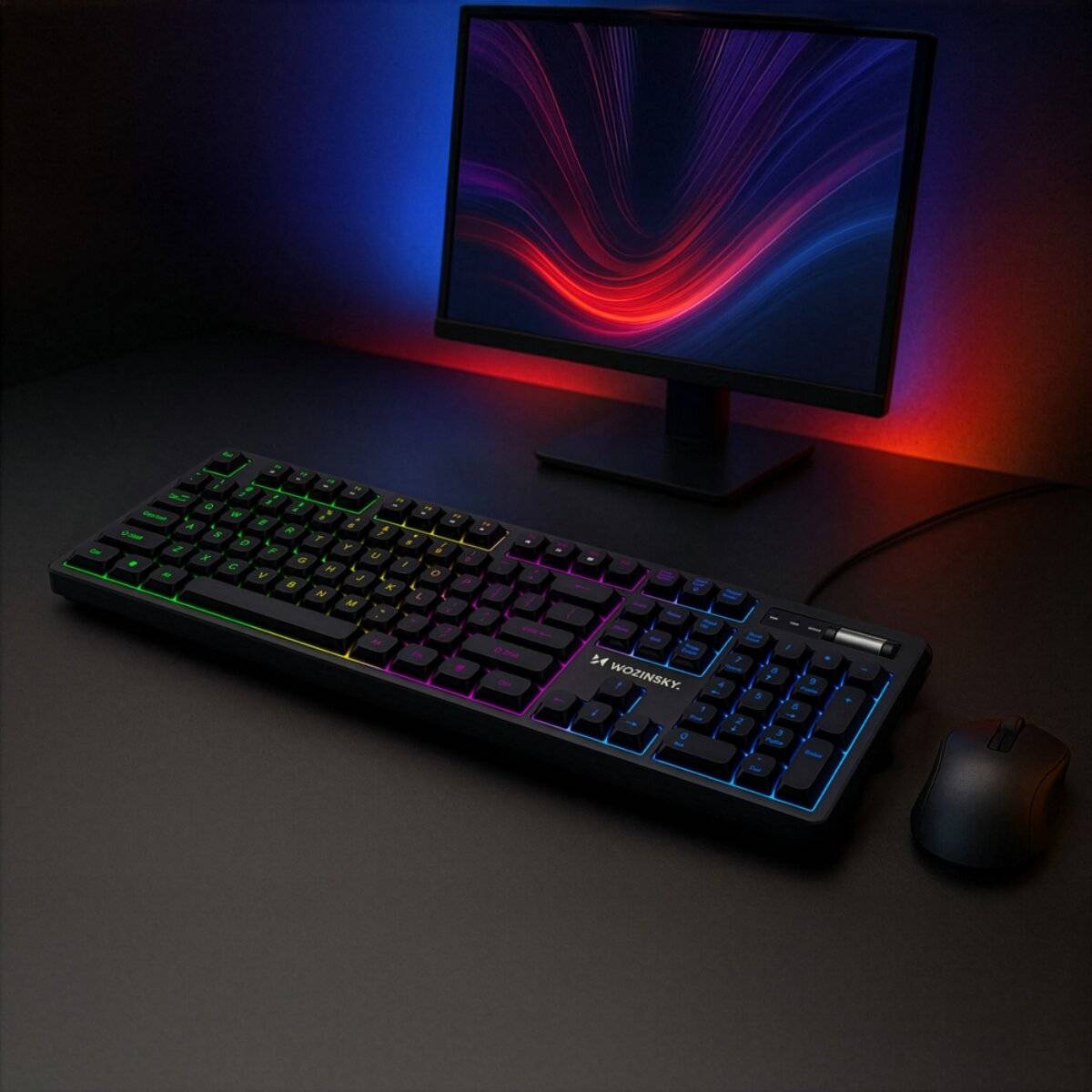 Ein Computer-Setup mit einer farblich beleuchteten Tastatur mit Hintergrundbeleuchtung, einer Maus und einem Monitor, der auf einem dunklen Schreibtischhintergrund lebendige Lichtmuster anzeigt.