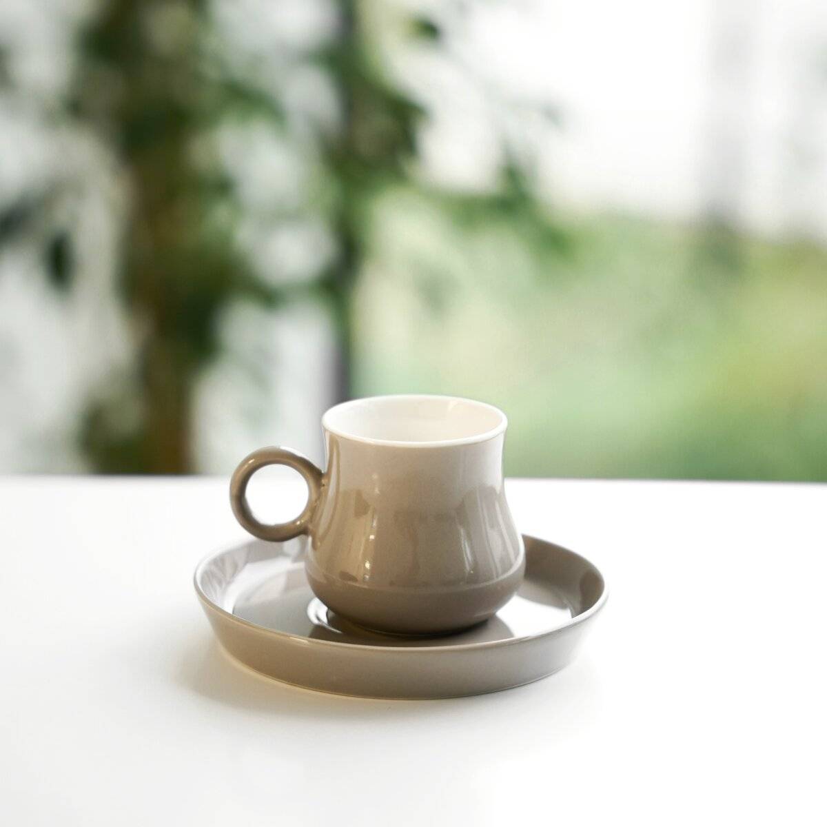 Ein elektrischer Weinflaschenöffner mit Kappen und eine Flasche Wein auf einem beigen Tuch, begleitet von Orangenscheiben und einer kleinen Pflanze.