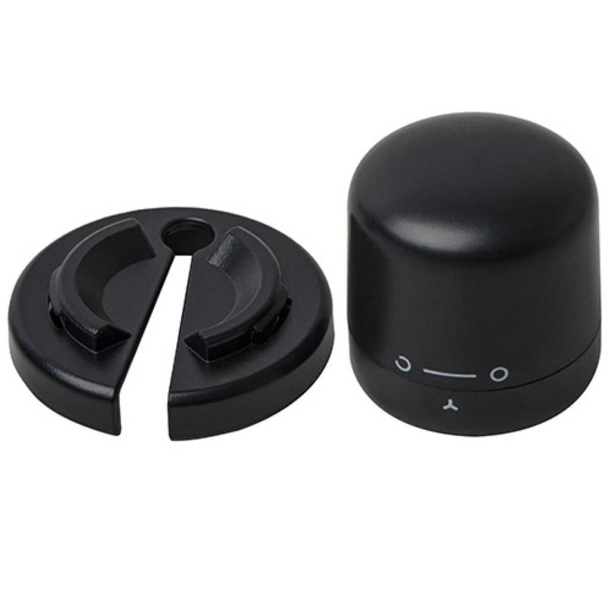 Ein kleines schwarzes Gerät mit einer abgerundeten Oberseite und einer abnehmbaren kreisförmigen Basis, die einfache Markierungen am unteren Ende zur Ausrichtung aufweist.