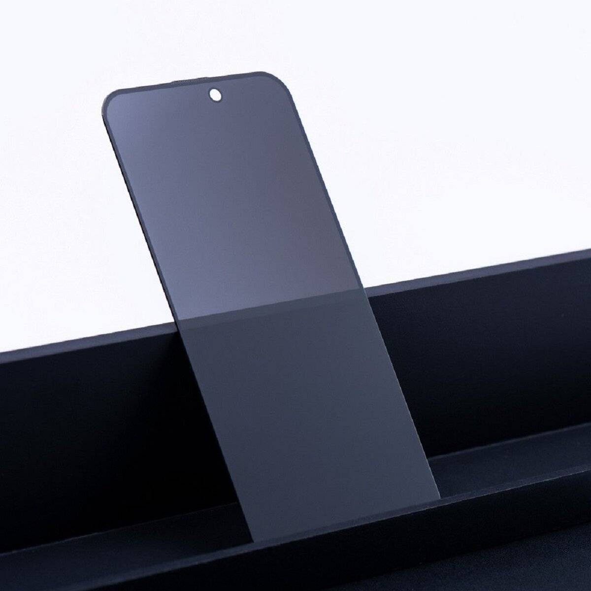 Ein elegantes, vertikal orientiertes Smartphone mit einer glatten, spiegelndend reflektierenden Glasoberfläche liegt schräg auf einer schwarzen Oberfläche.