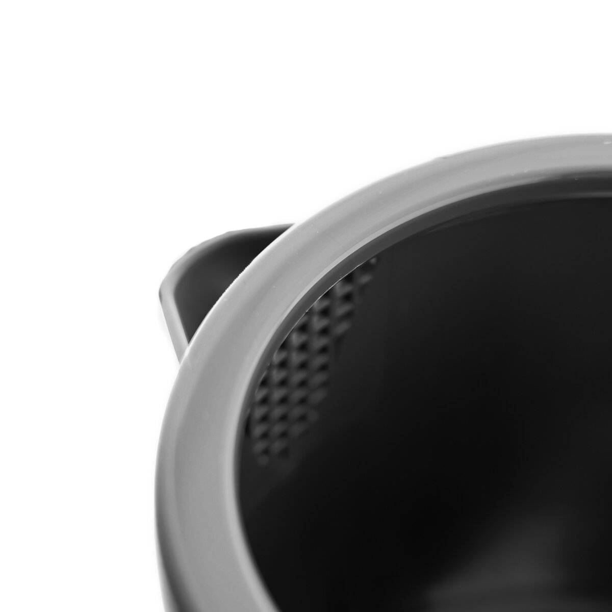 Eine Nahaufnahme eines schwarzen, leeren, runden Behälters mit einem Griff, fotografiert aus einem oberen Winkel, der seine glatte, reflektierende Oberfläche zeigt.