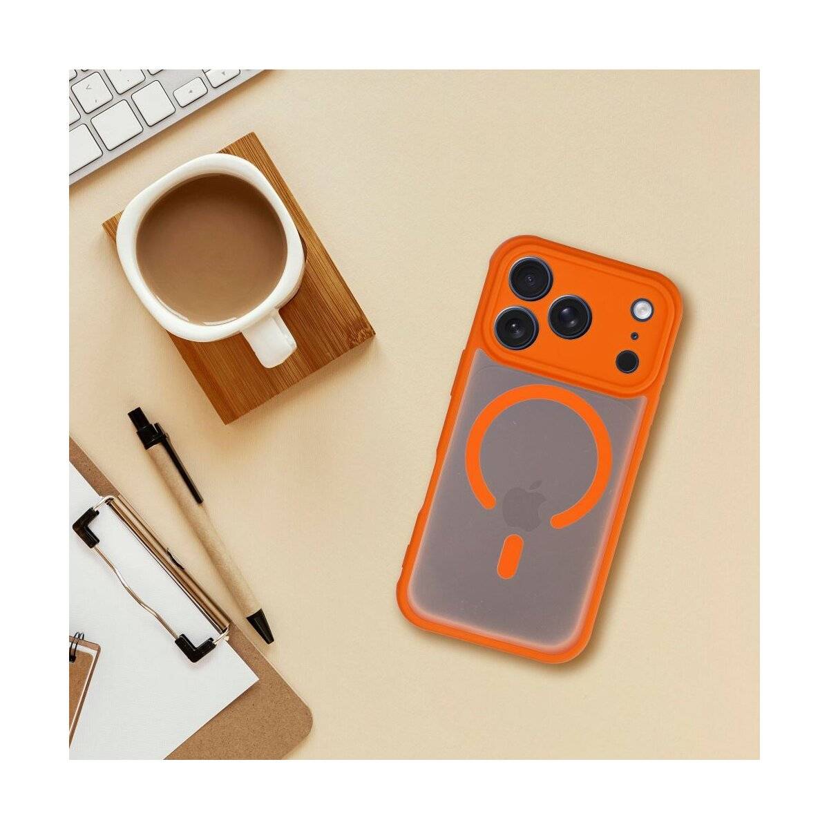 Orange Handyhülle mit Ringdesign neben einer Kaffeetasse auf einem Holzuntersetzer, Stift und Notizbuch auf einer beigen Oberfläche.