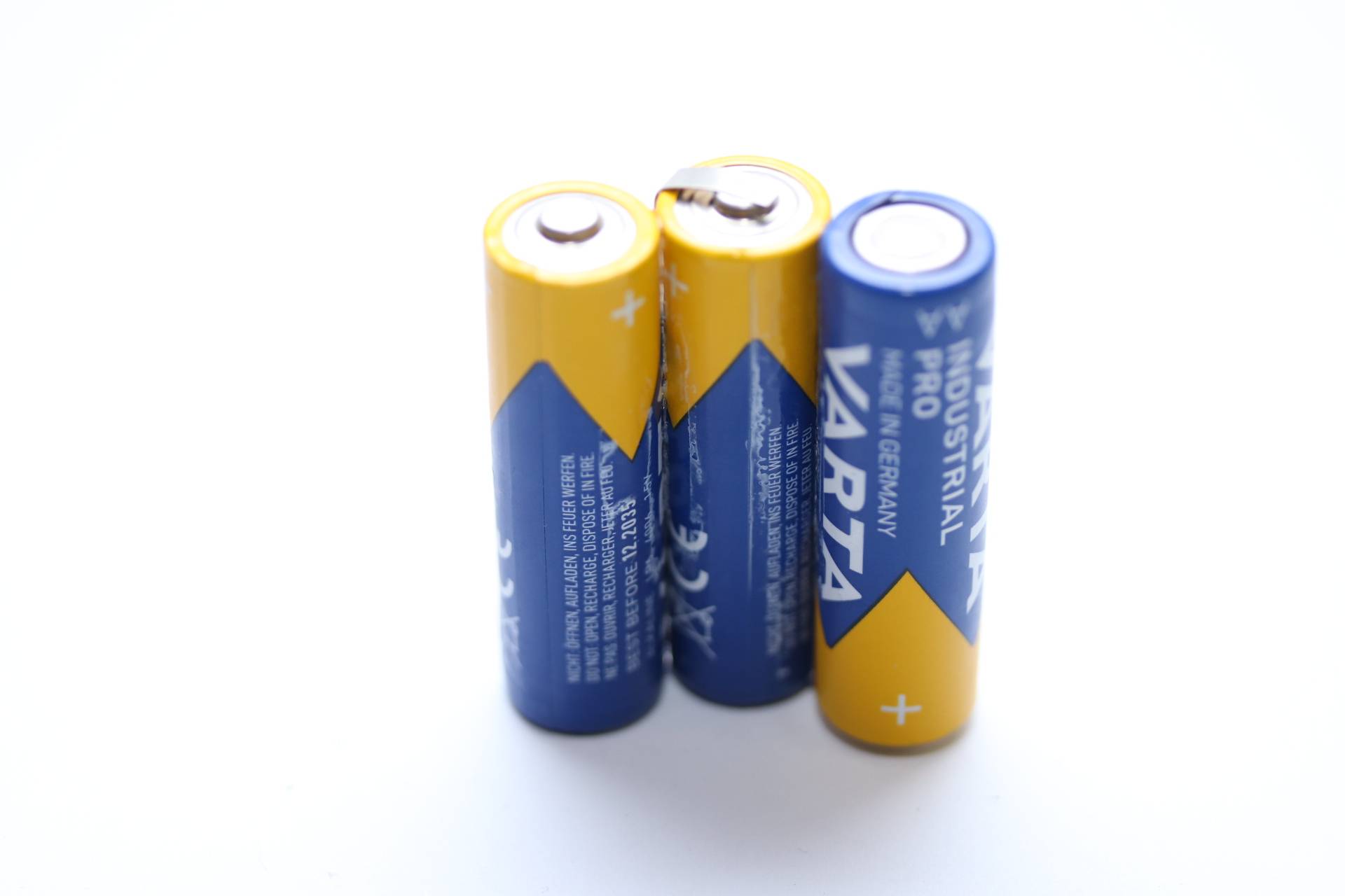 Drei AA-Industriebatterien aufrecht stehend, mit sichtbaren Plus- und Minuspolen, mit der Aufschrift „Made in Germany