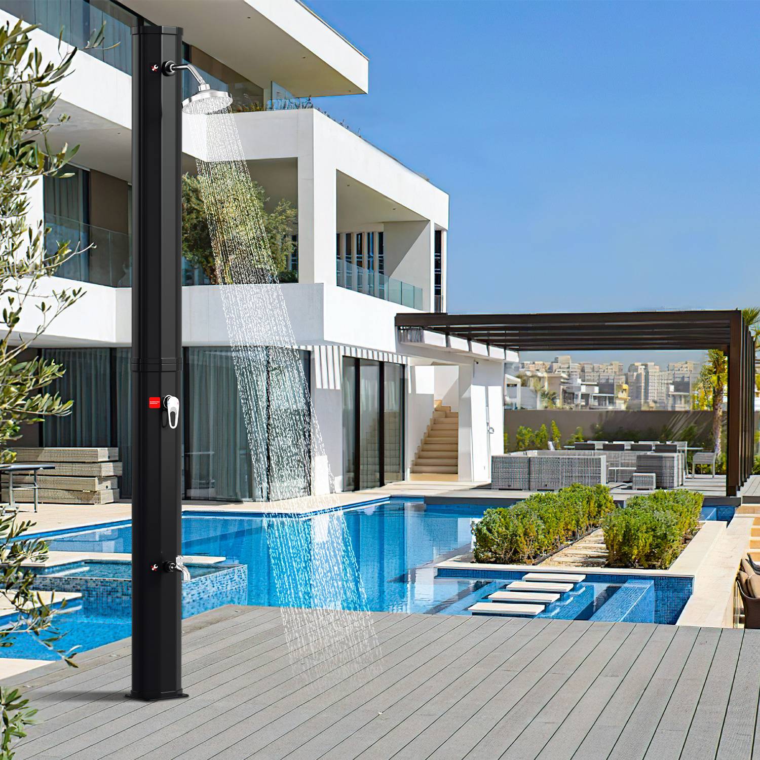 Moderne Außendusche an einem Pool neben einem zeitgenössischen Haus, mit Liegestühlen und Grünflächen rundherum. Klarer blauer Himmel im Hintergrund.