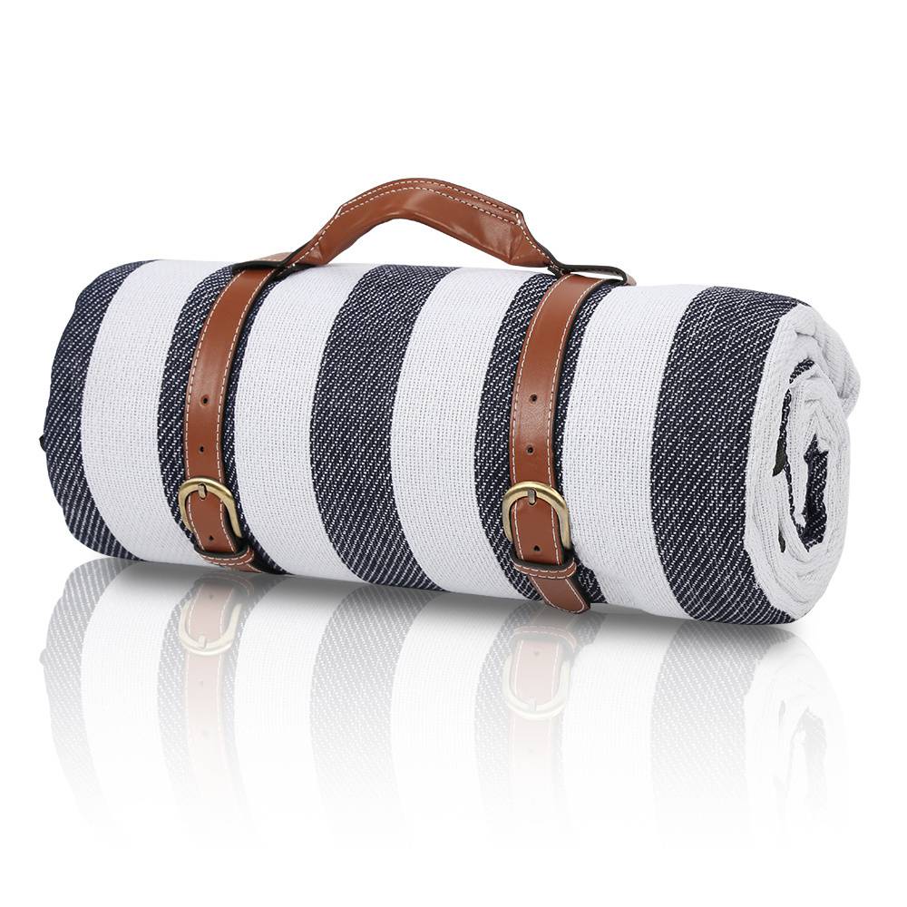 Eine aufgerollte Decke mit blauen und weißen Streifen, gesichert durch braune Ledergurte mit Schnallen, mit einem Griff zum einfachen Tragen.
