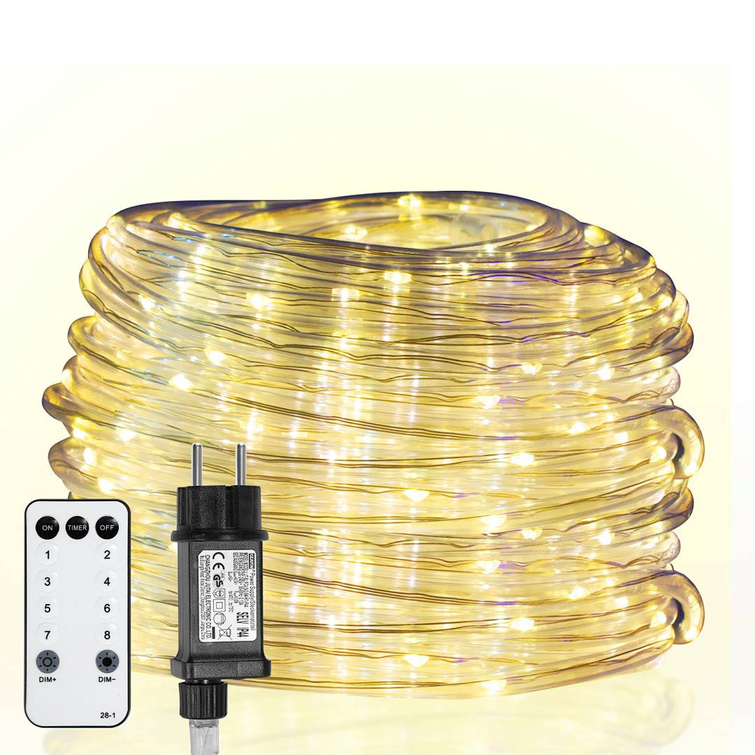 Ein aufgerolltes Band mit warmweißen LED-Leuchten neben einem schwarzen Stecker und einer weißen Fernbedienung mit nummerierten Tasten zum Ändern der Modi.