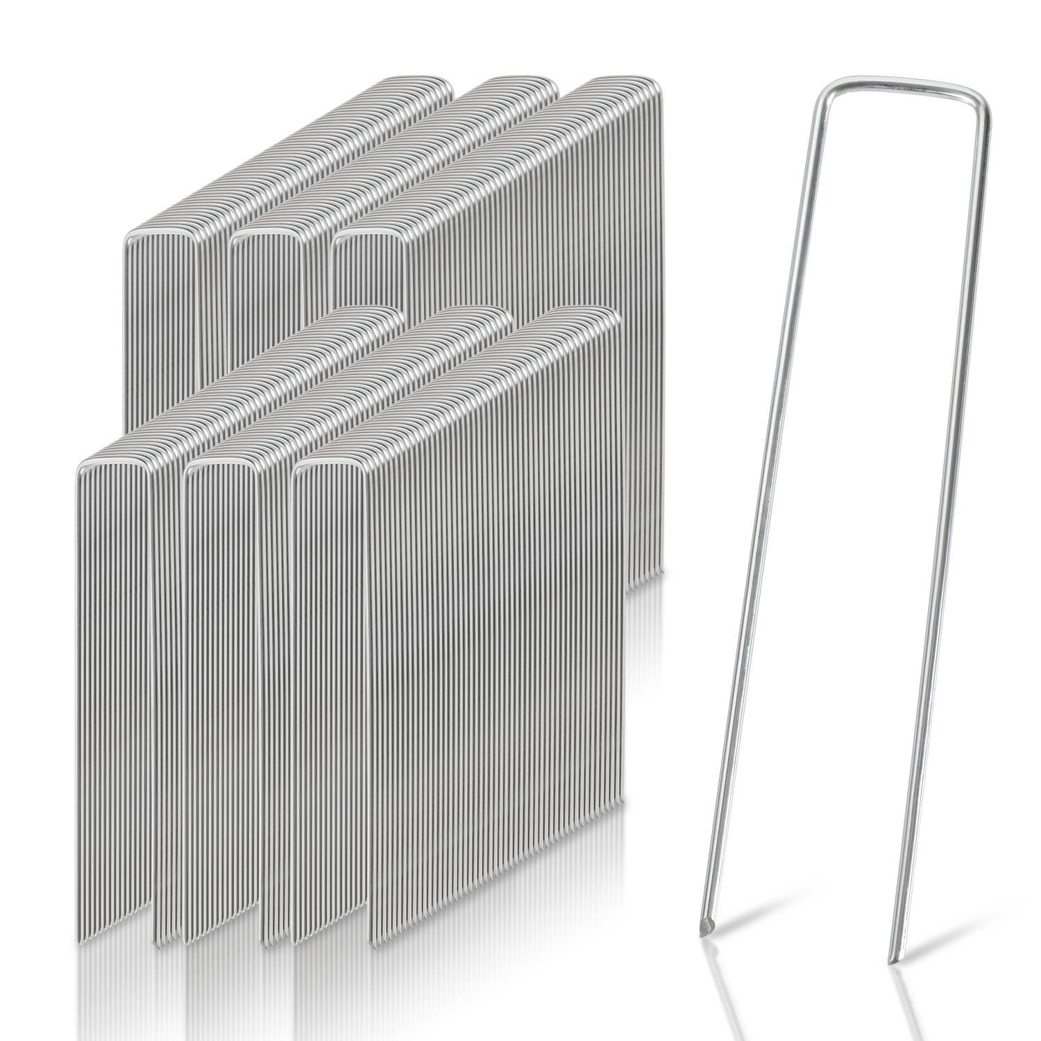 Mehrere Stapel von U-förmigen Metallgartenaufstecken neben einem einzelnen Aufstecker zur Veranschaulichung von Größe und Form. Wird zum Befestigen von Landschaftsvlies verwendet.