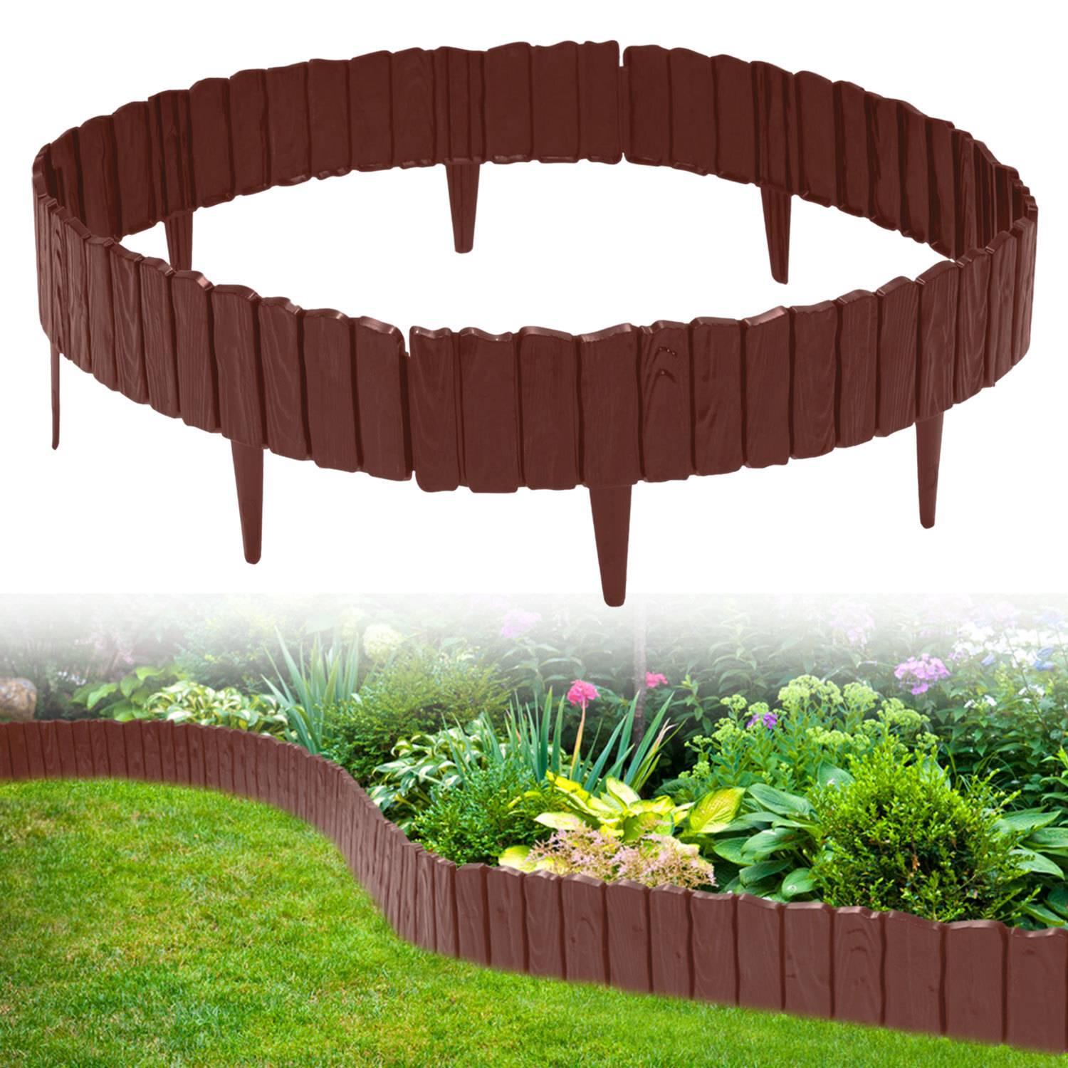 Braun gefärbter Gartenzaun mit spitzen Pfosten bildet eine kreisförmige Begrenzung; wird verwendet, um ein Blumenbeet von einer Rasenfläche zu trennen.