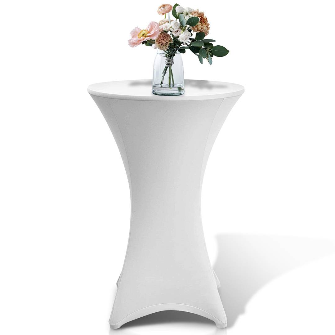 Ein kleiner weißer runder Tisch mit einer passenden Abdeckung trägt eine Glasvase mit gemischten Blumen, einschließlich rosa und weißer Blüten, auf seiner Oberfläche.