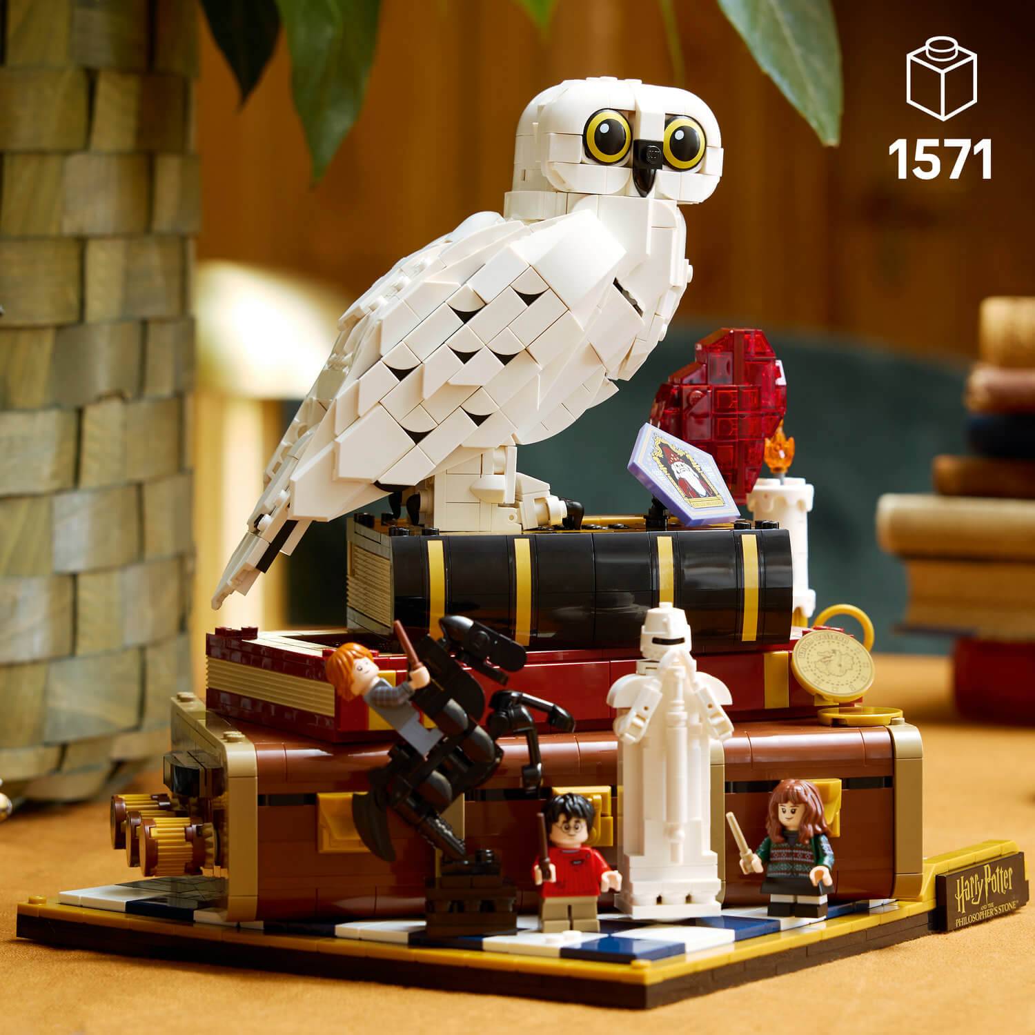 Ein detailliertes LEGO-Bauwerk mit einer Eule auf Büchern, Harry-Potter-Minifiguren und Artefakten, Satznummer '1571'.