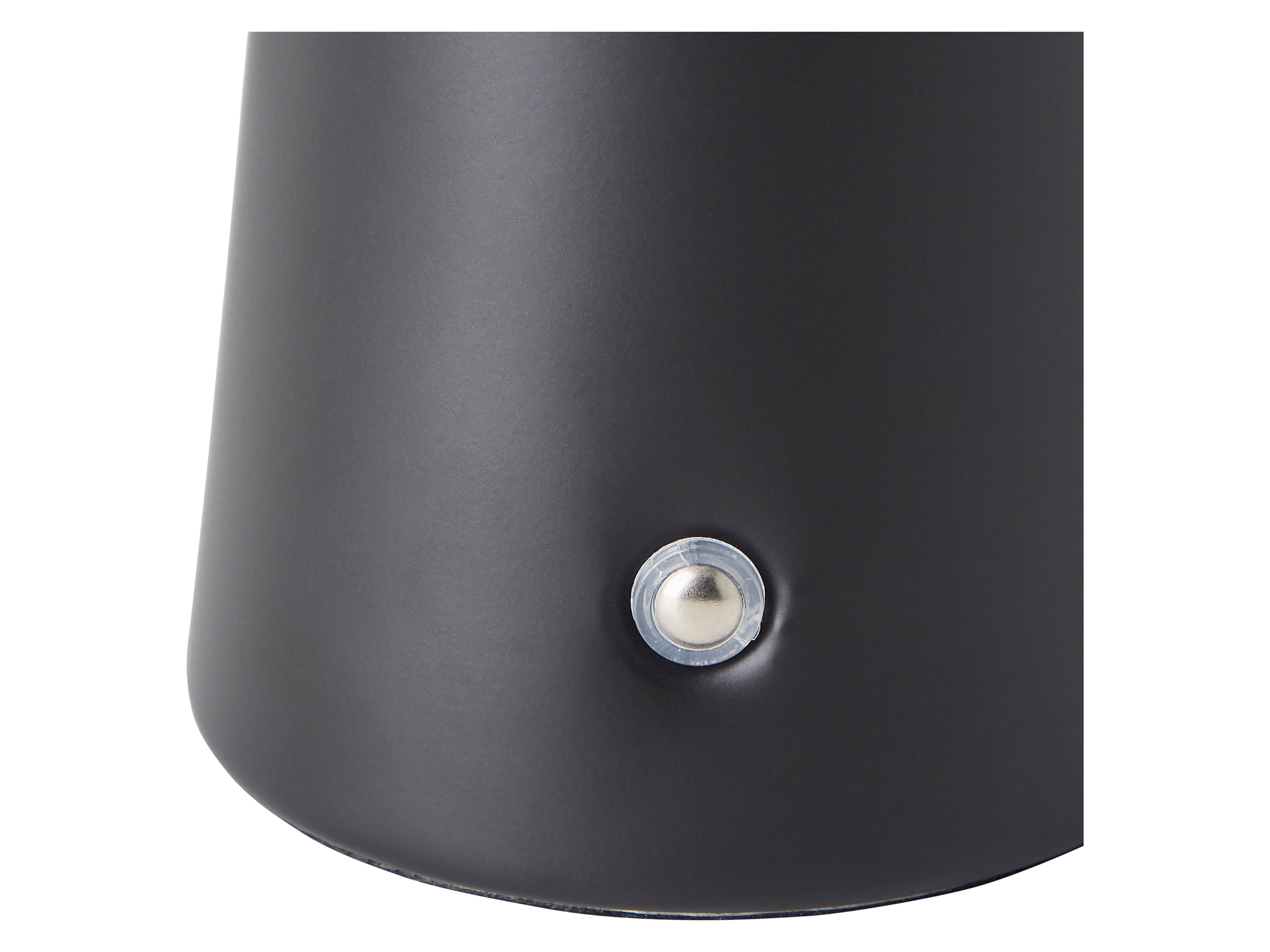 Eine Nahaufnahme einer schwarzen Metalloberfläche mit einem kleinen, runden, silbernen Knopf, der daran befestigt ist.