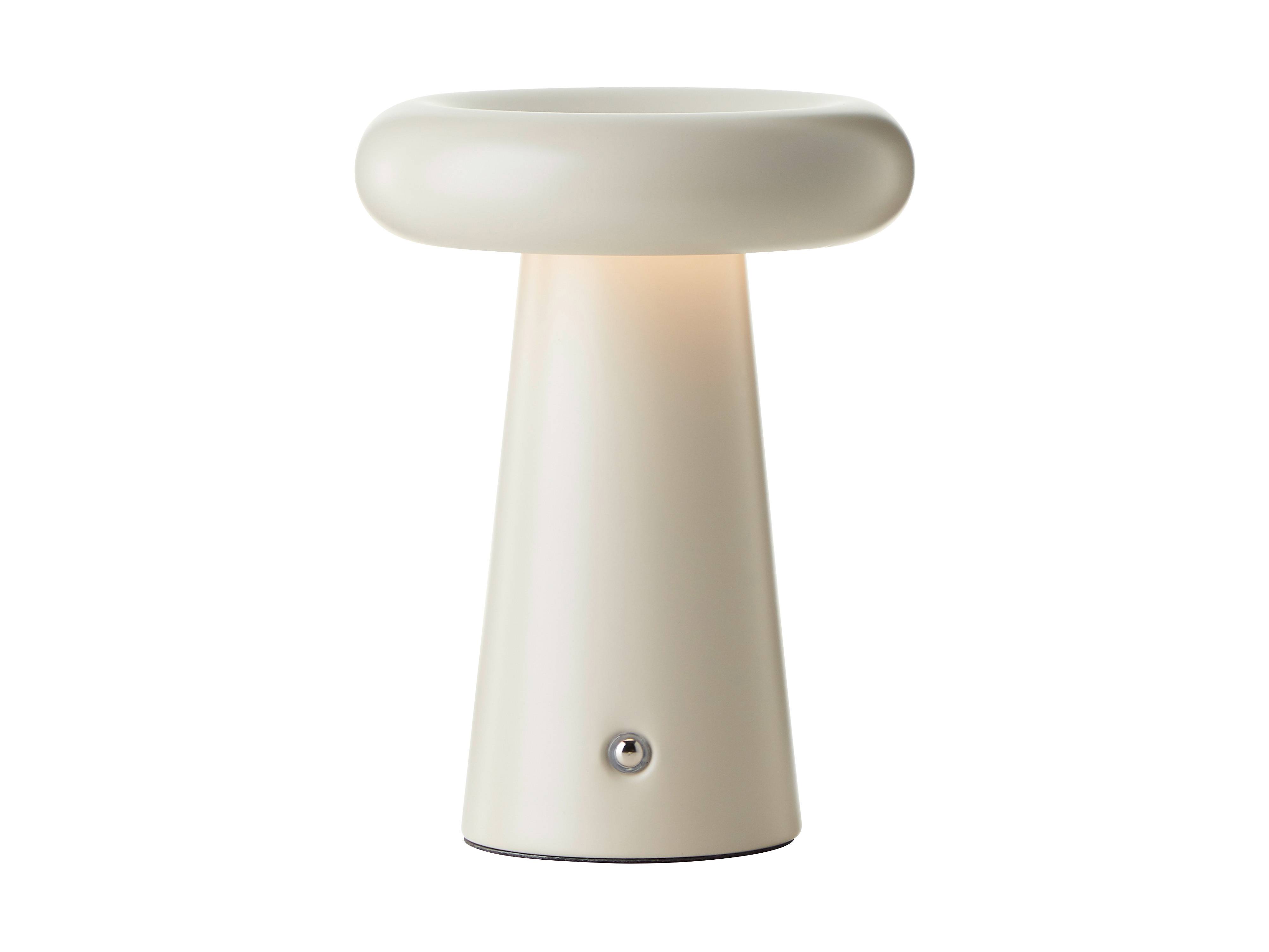 Eine cremefarbene moderne Tischlampe mit einer breiten, abgerundeten Oberseite, die einen kleinen Bedienungsknopf an der Basis aufweist.