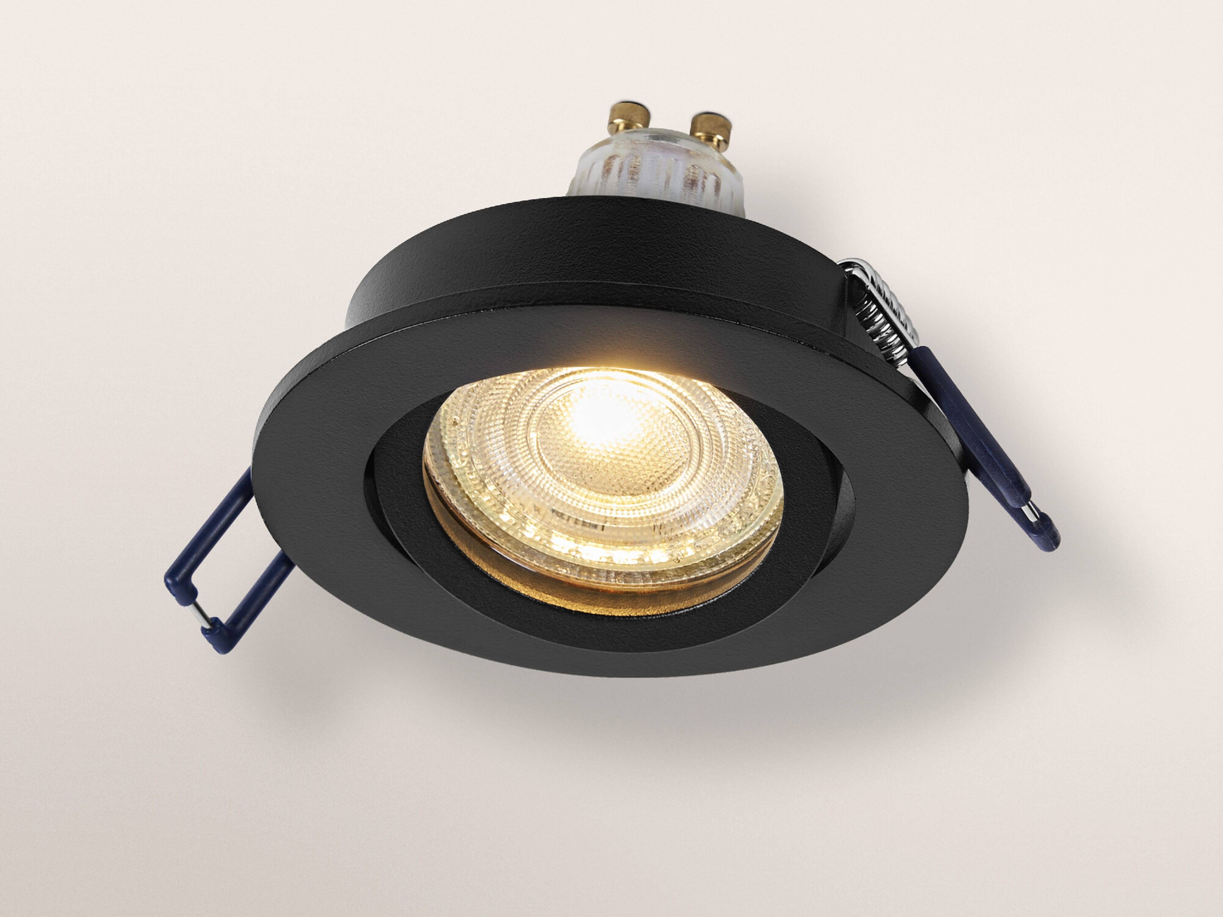 Eine runde, schwarze eingelassene Deckenleuchte wird gezeigt, deren leuchtende Glühbirne die Umgebung beleuchtet.