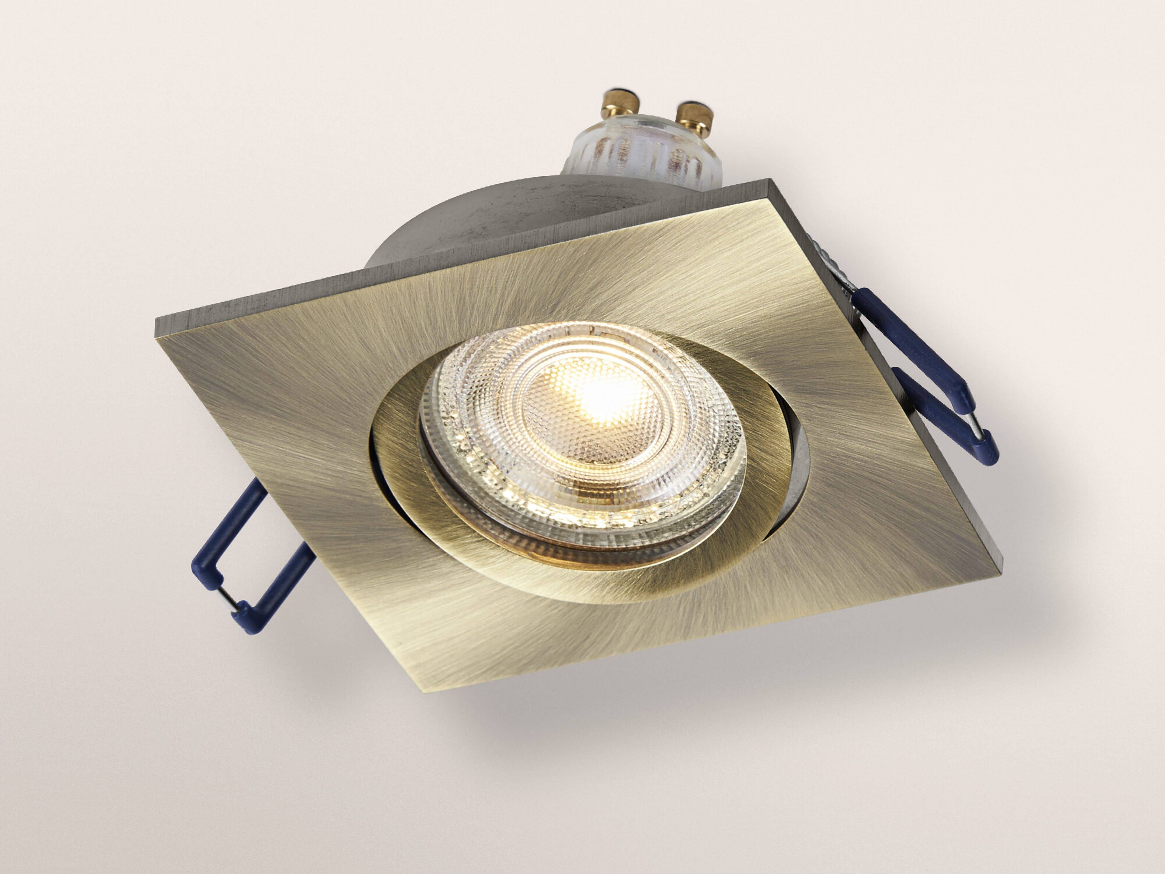 Ein quadratisches, gebürstetes Deckeneinbauleuchten-Element aus Metall mit einer leuchtenden Glühbirne, in einem Winkel montiert, vor einem neutralen Hintergrund.