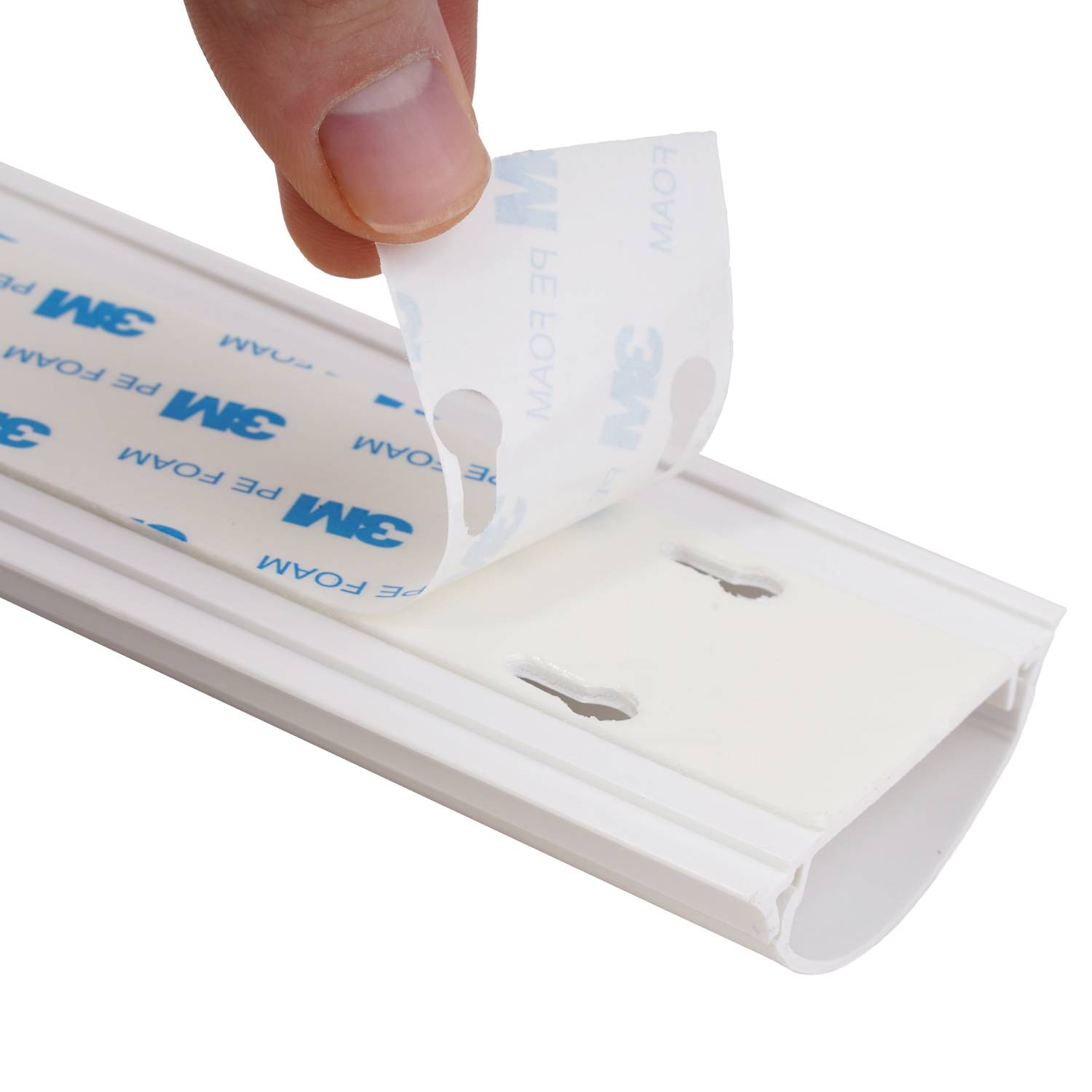 Eine Hand, die eine Schutzschicht von Klebeband auf einem Kunststoffstreifen abzieht und den Prozess der Vorbereitung des Streifens zum Anbringen zeigt.