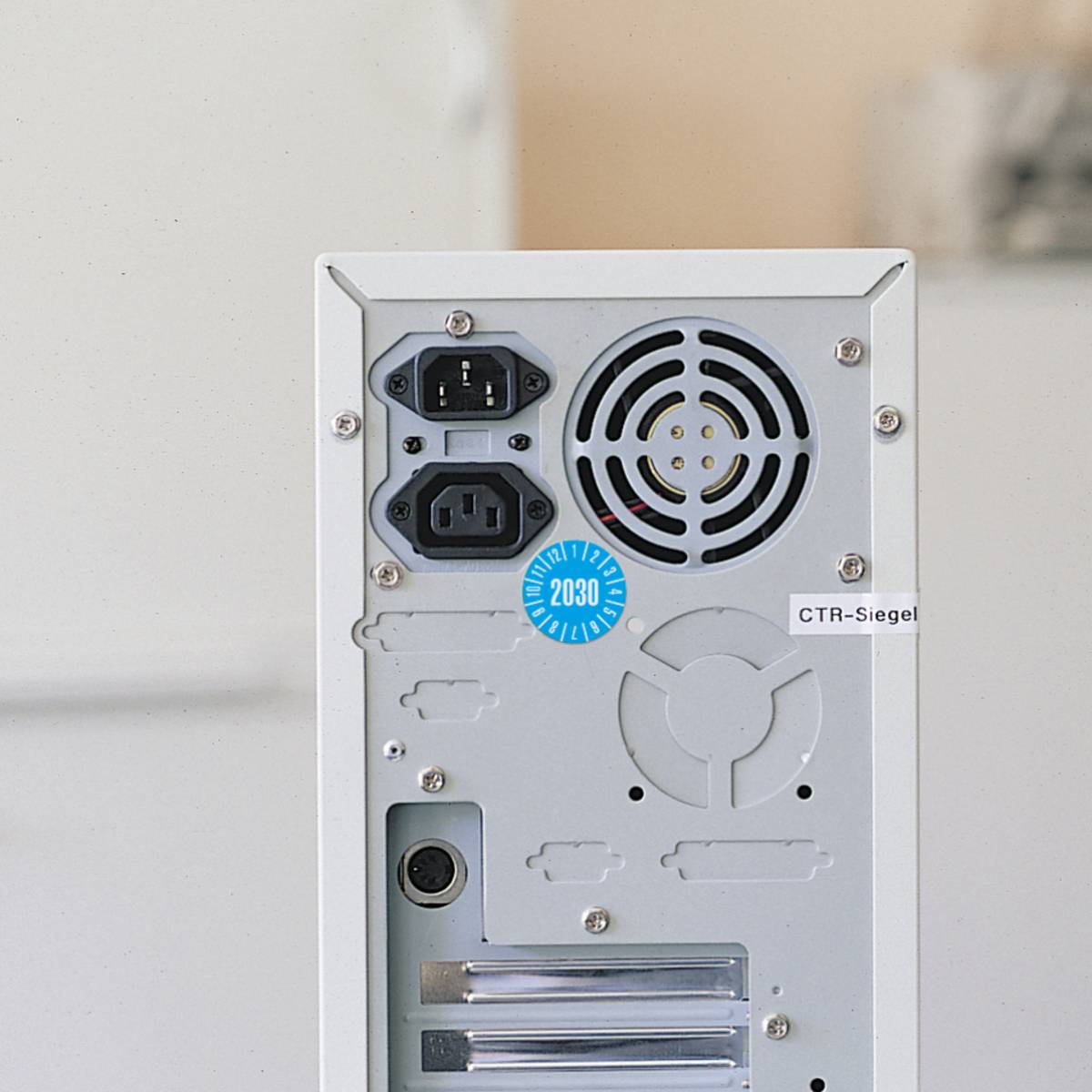 Die Rückseite eines Computer-Towers mit Stromsteckdosen, einem Lüftungsventilator und einem „2030