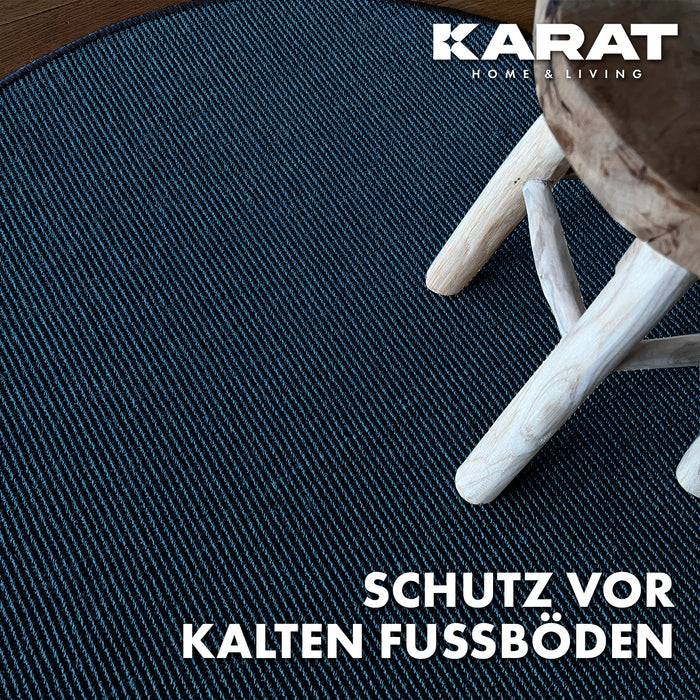 Ein gewebter blauer Teppich mit hellen Holzstuhlbeinen darauf. Der Text lautet „Schutz vor kalten Fußböden