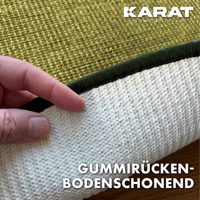 Hand hebt einen strukturierten, grünrückigen Teppich mit weißer Gummiunterlage an. Text lautet „Gummirücken-Bodenschonend