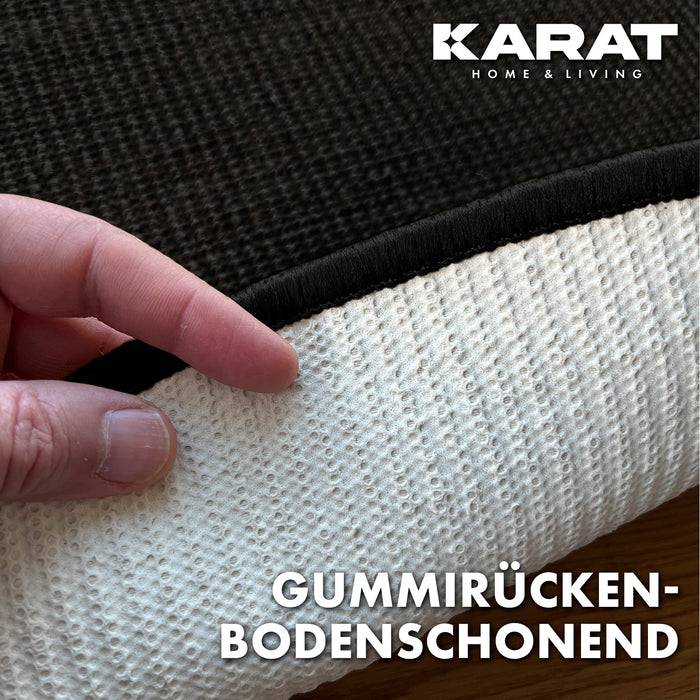 Eine Hand, die die Unterseite eines Teppichs mit Gummirücken zeigt. Der Text lautet „Gummirücken-bodenschonend