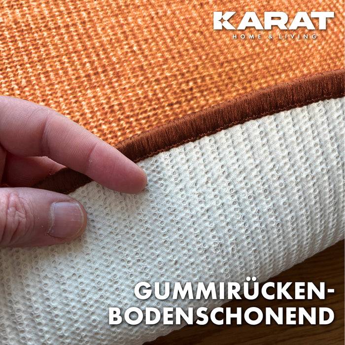 Eine Hand hebt einen Teppich an, um die rutschfeste Gummirückseite zu zeigen. Der Text lautet „Gummirücken-bodenschonend