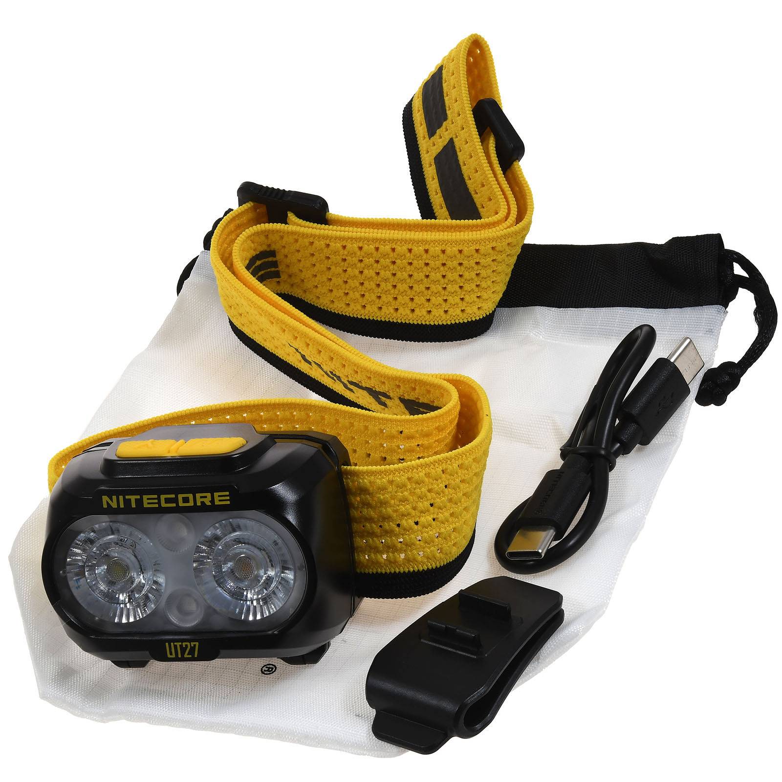 Gelb-schwarze Nitecore UT27 Stirnlampe mit verstellbarem Kopfband, USB-Kabel und Clip in einem weißen Beutel mit Zugband.