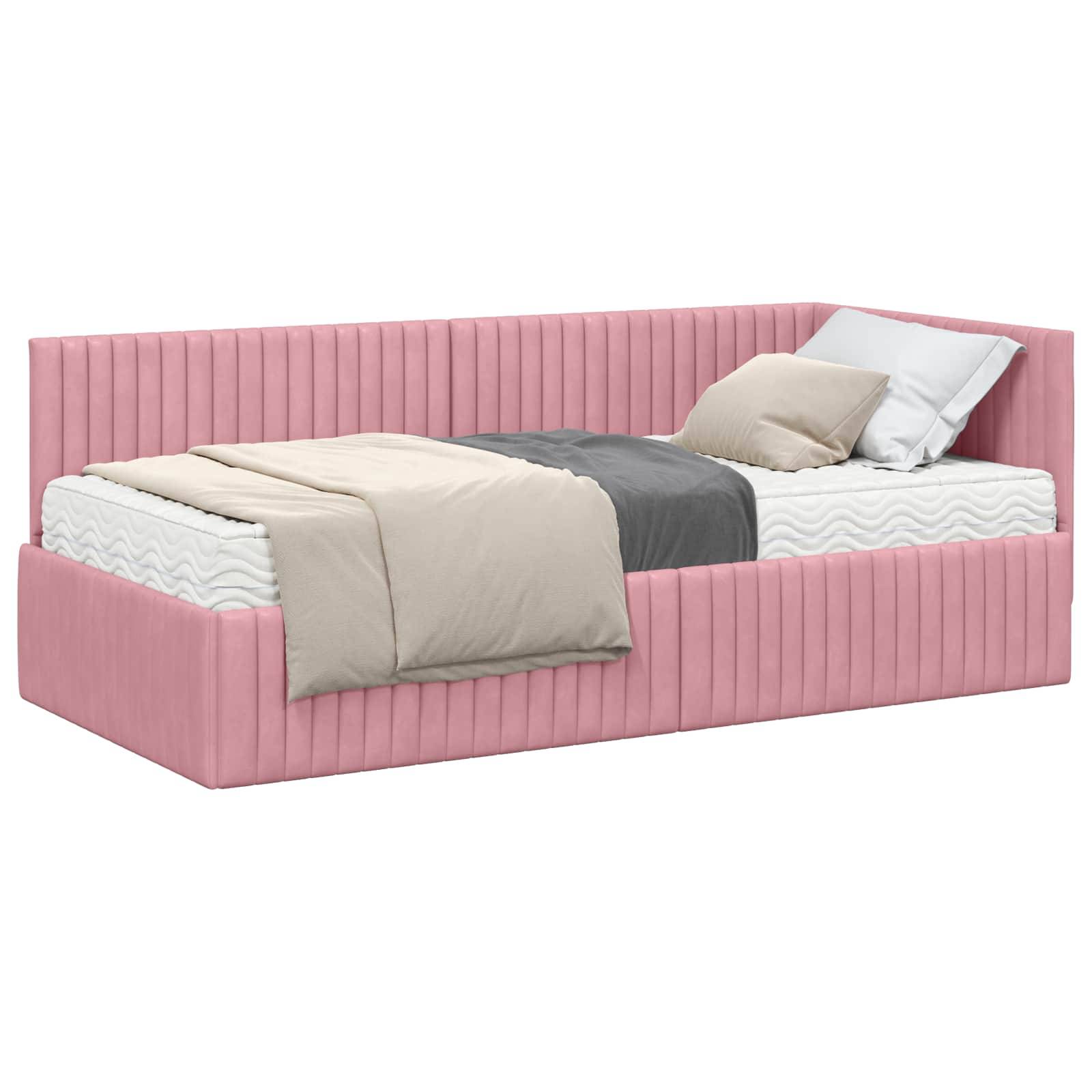 Ein rosa gepolstertes Tagesbett mit Matratze, Kissen und beige- und grauer Bettwäsche, aus einem Winkel betrachtet, das die gepolsterte Rückenlehne und Seiten des Bettes zeigt.
