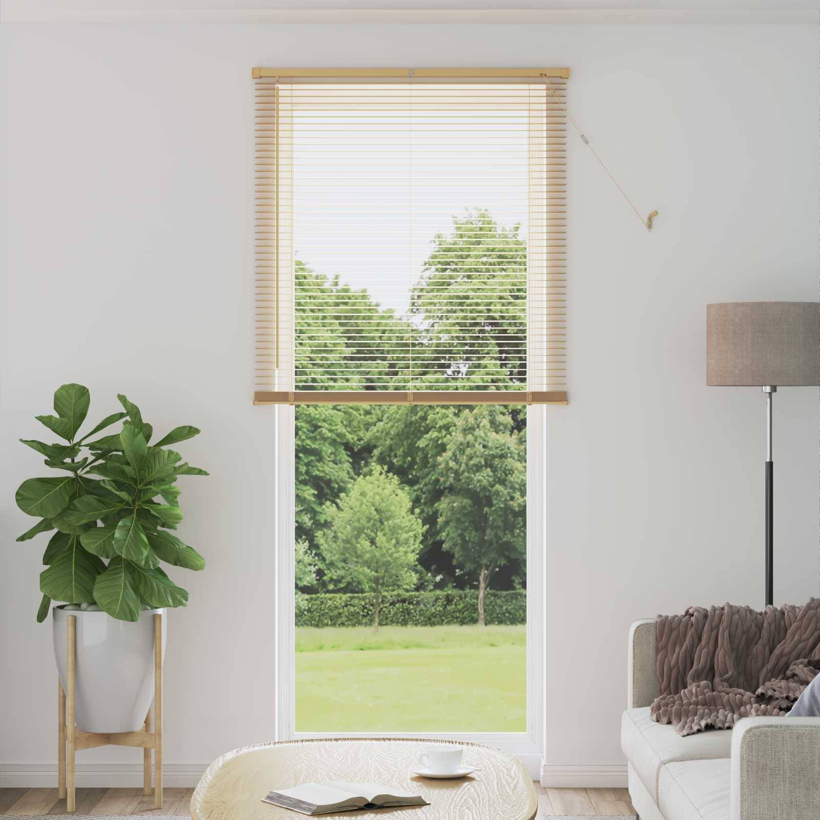 Ein gemütliches Wohnzimmer mit einem großen Fenster, das einen grünen Garten zeigt, einer Topfpflanze auf der linken Seite, einem beigen Sofa auf der rechten Seite und einer Stehlampe.