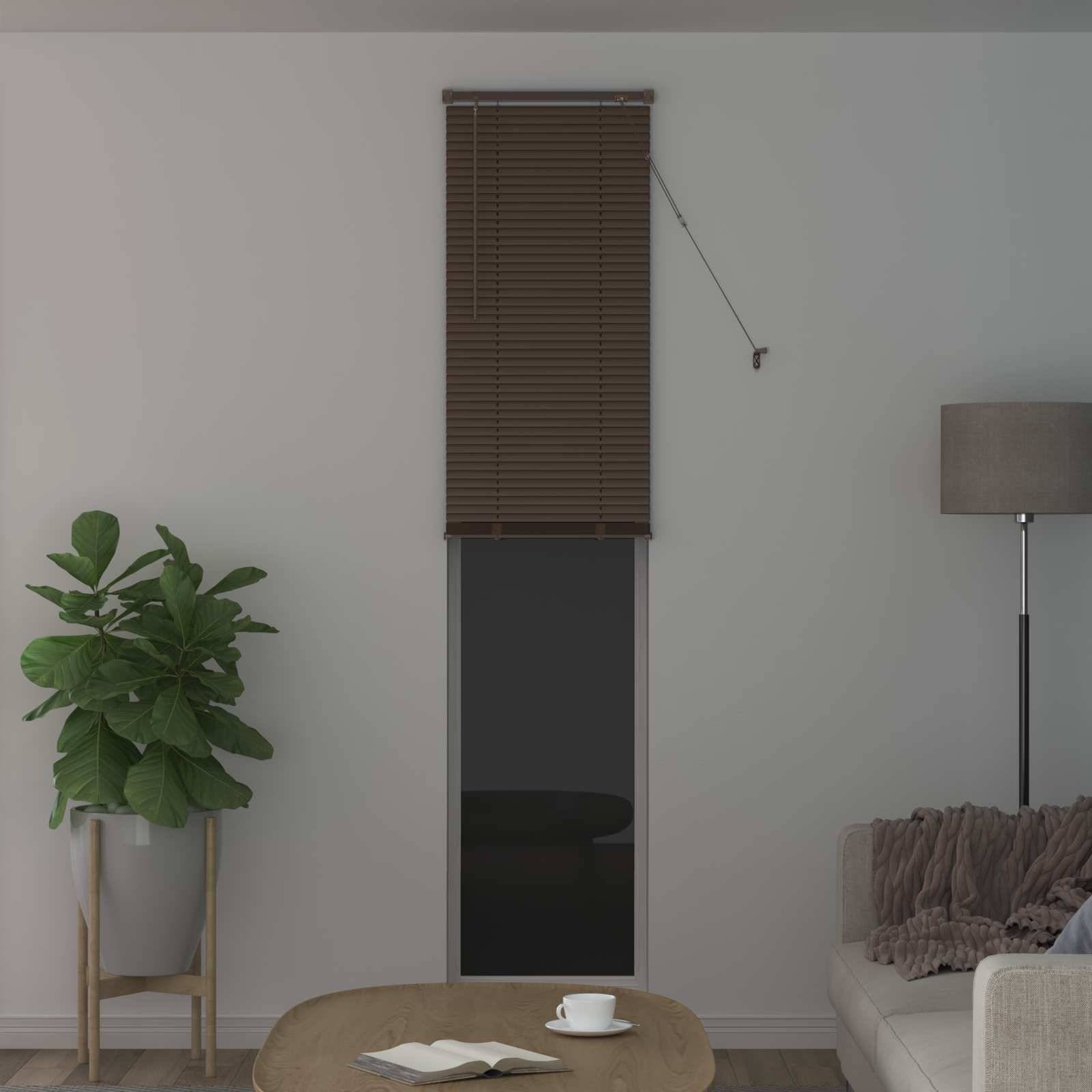 Ein gemütliches Wohnzimmer mit einer Topfpflanze, einem kleinen runden Couchtisch und einer Stehlampe neben einem hellgrauen Sofa. An der Wand befindet sich ein Fenster mit geschlossenen Jalousien.