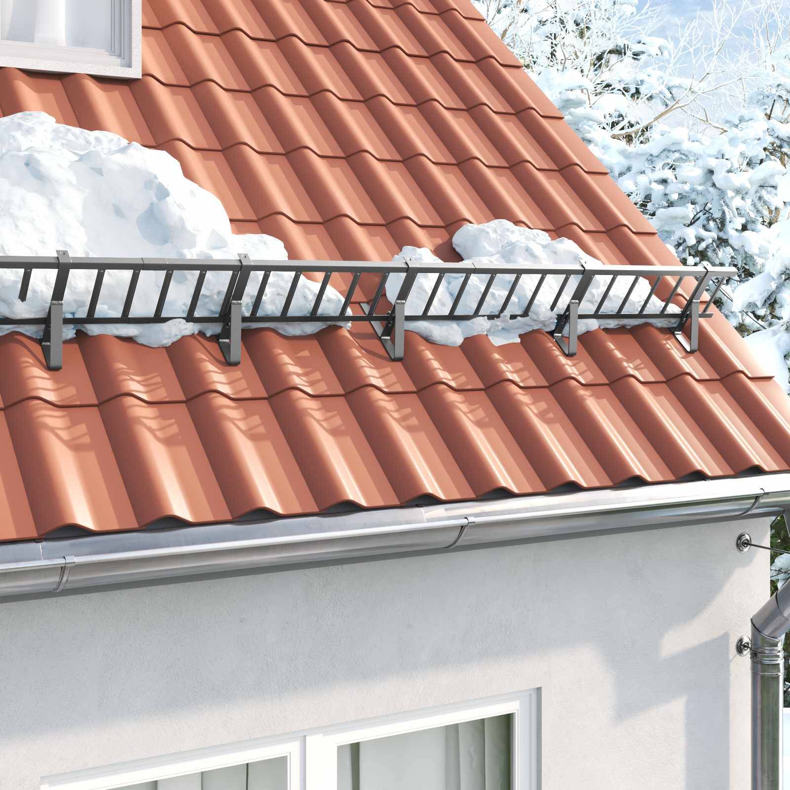 Ein schneebedecktes Hausdach mit installierter Schneefanggitter, umgeben von schneebedeckten Bäumen.