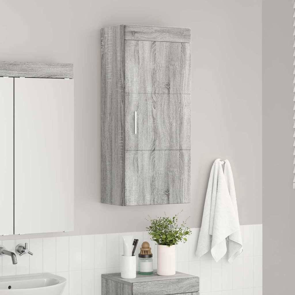 Ein Badezimmer mit einem grauen Holzschrank, einem Handtuch, das an der Wand hängt, und einer kleinen Vase mit Blumen neben einem Waschbecken.