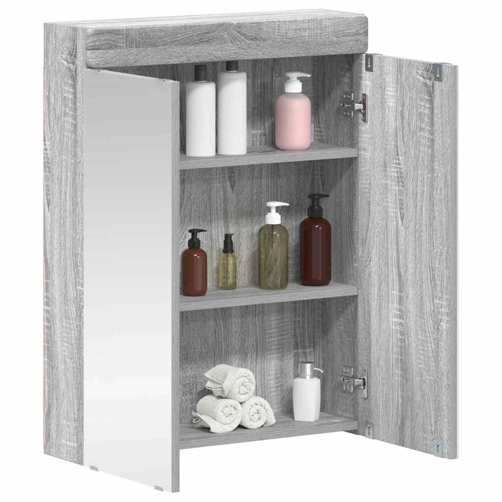 Ein grauer Holzbadezimmerschrank mit zwei offenen Türen, die Regale zeigen. Er enthält verschiedene Flaschen und aufgerollte Handtücher im Inneren.