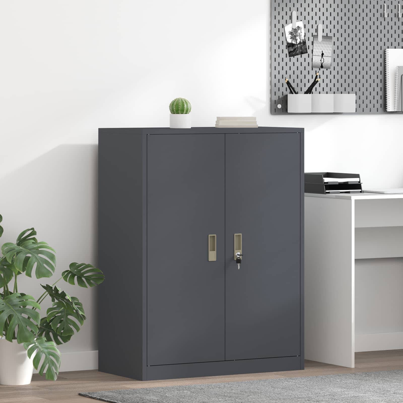 Eine moderne Büroecke mit einem dunkelgrauen Schrank, weißem Schreibtisch, Pflanzen und einer Pinnwand an der Wand, die ein minimalistisches und sauberes Setup zeigt.