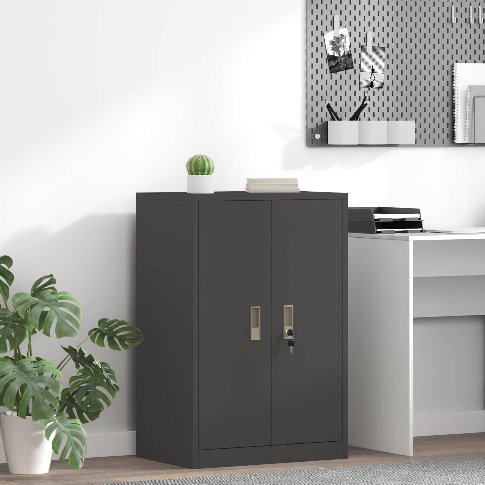 Ein kleines Büro mit einem schwarzen Schrank, einem weißen Schreibtisch und einer Pflanze. Ein Pinnwand mit Fotos und Notizen ist über dem Schreibtisch angebracht.