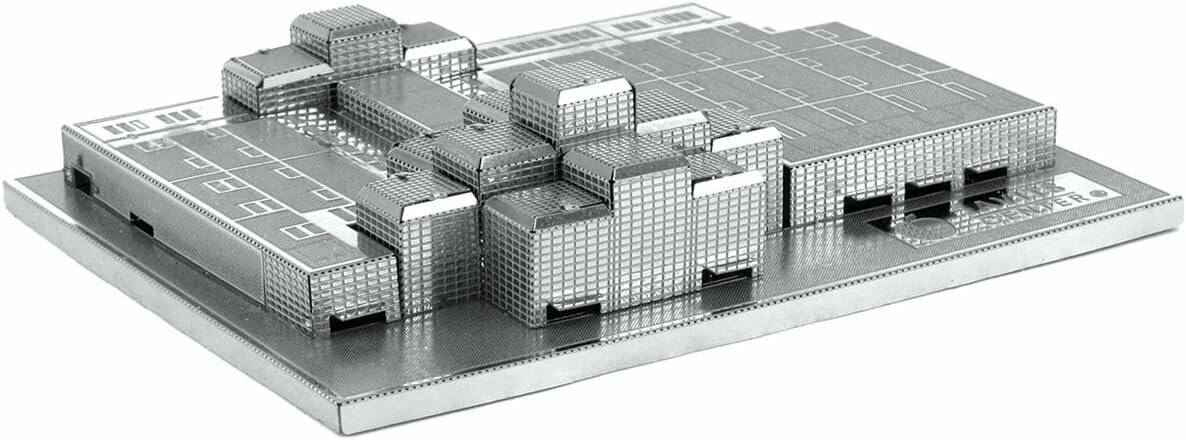 Ein Metallmodell einer modernen Stadtlandschaft mit einer Ansammlung geometrischer Gebäude mit einem gitterartigen Design, das urbane Architektur darstellt.
