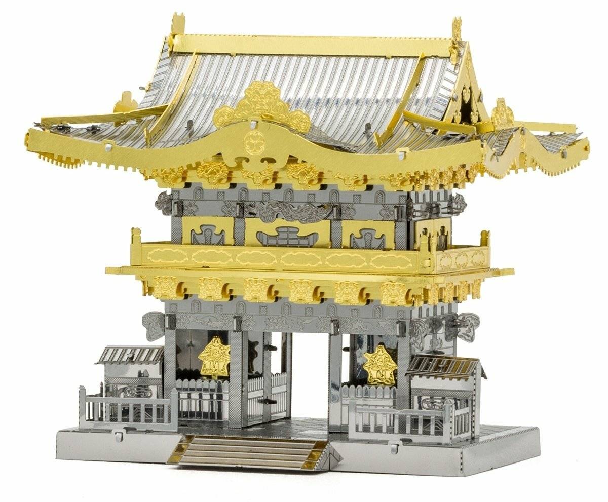 Ein Metallmodell eines traditionellen japanischen Tempeltors, kunstvoll detailliert, mit goldenen und silbernen Farben, das aufwendige architektonische Merkmale zur Schau stellt.
