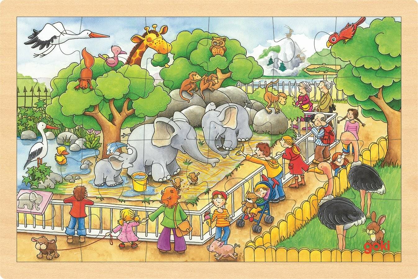 Kinder und Eltern beobachten Elefanten und andere Tiere in einer zooähnlichen Umgebung. Verschiedene Tiere, darunter Giraffen und Affen, sind sichtbar.
