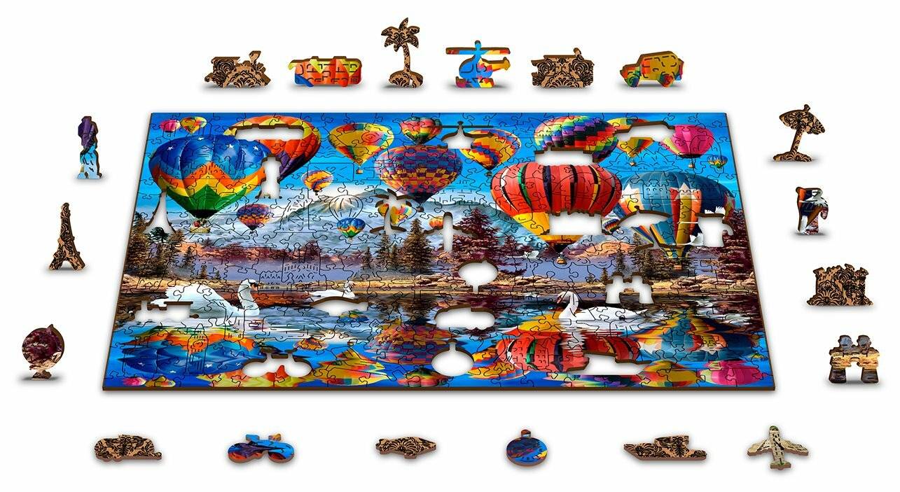 Puzzle mit bunten Heißluftballons in einem blauen Himmel über einem See mit Schwänen, umgeben von Puzzleteilen in Form verschiedener Objekte.