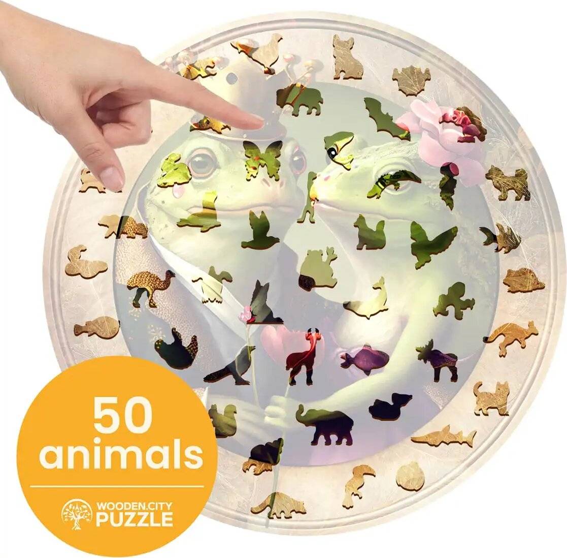 Eine Hand zeigt auf ein Puzzle mit 50 tierförmigen Teilen, die ein Bild von zwei sich gegenüber stehenden Fröschen bilden. Text: „50 Tiere, Wooden City Puzzle.
