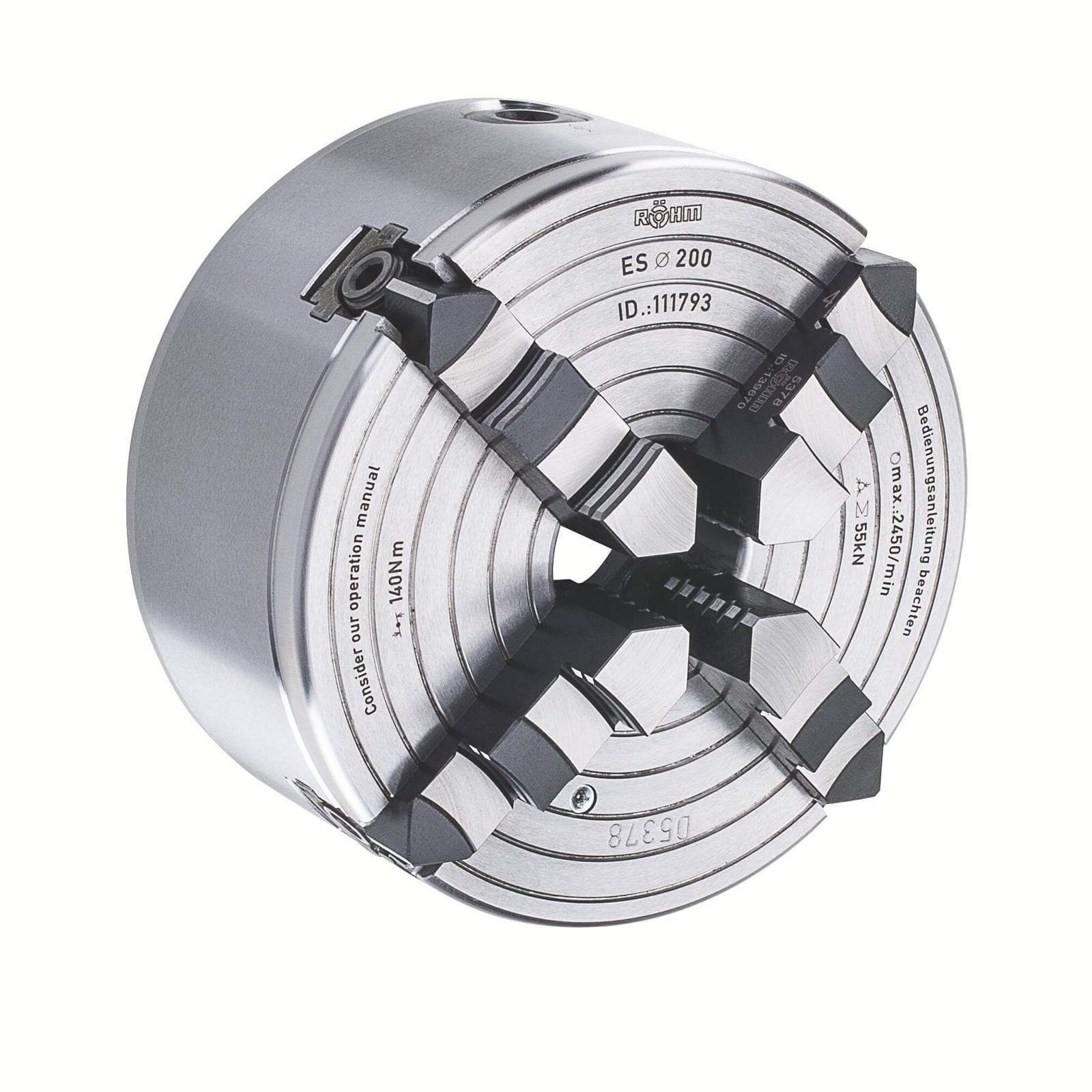 Ein grauer Metallspannfutter mit vier Backen zum sicheren Halten von Objekten in Drehmaschinen. Seriennummern und Produktinformationen sind auf der Oberfläche eingraviert.