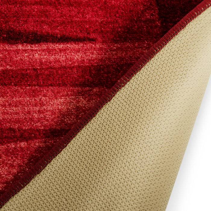 Roter Bereichsteppich mit einer verblassten Textur, leicht gerollt, um seine beige rutschfeste Rückseite zu zeigen.