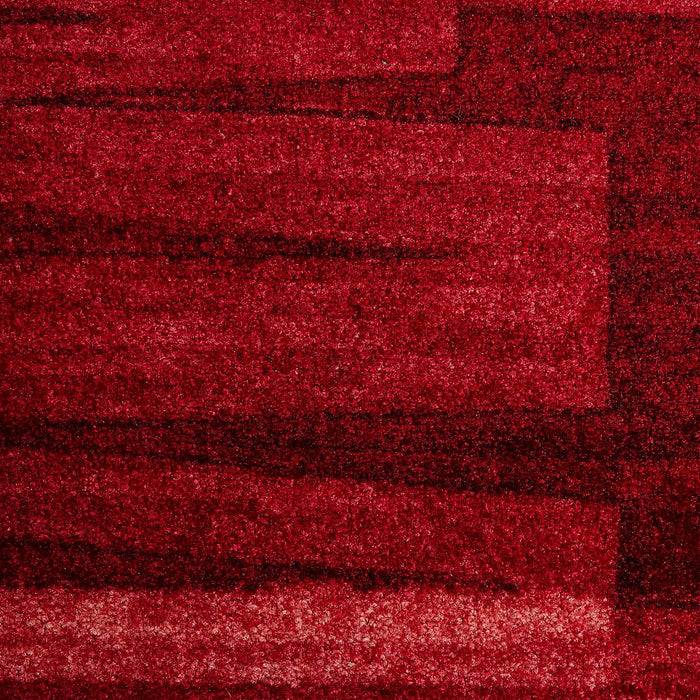 Ein strukturierter roter Teppich mit unterschiedlichen Farbtönen und Flecken von tiefem Karminrot, der eine weiche und luxuriöse Oberfläche suggeriert.