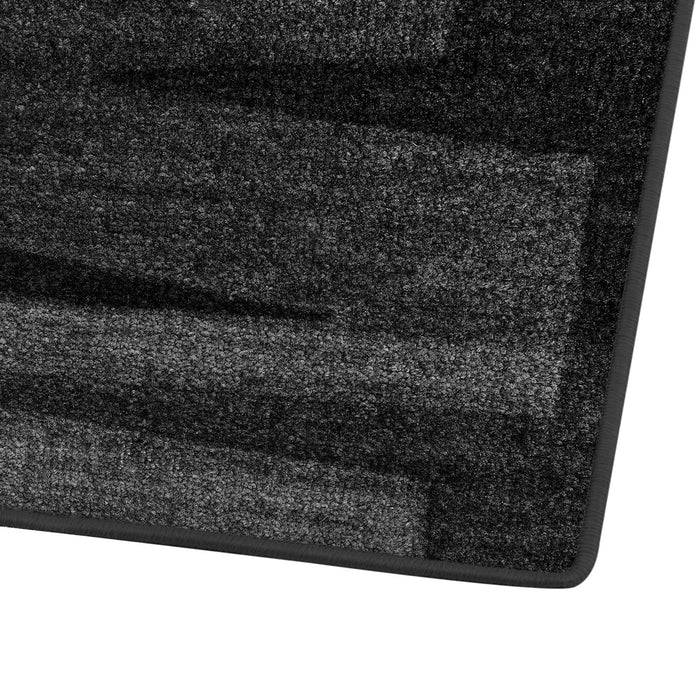 Eine Nahaufnahme eines strukturierten, grauen rechteckigen Teppichs mit einem Farbverlaufsmuster, das verschiedene Grautöne aufweist und eine geschichtete Wirkung erzeugt.