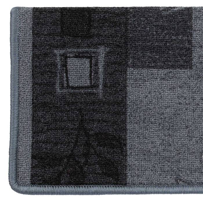 Ein rechteckiger Teppich mit pixeliertem Design in verschiedenen Grautönen, einschließlich eines quadratischen Musters in der Mitte und gerahmten Kanten.