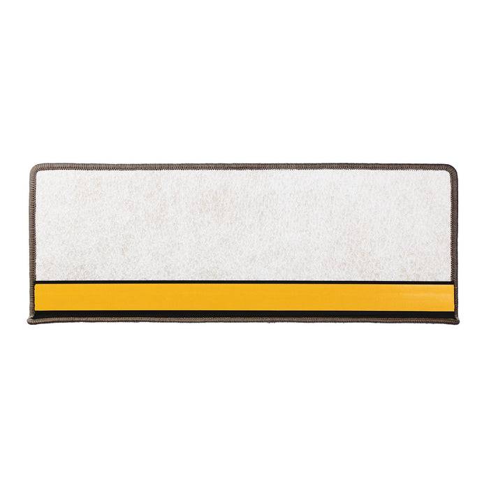 Eine rechteckige Fußmatte in Weiß und Gelb mit Gummikante.