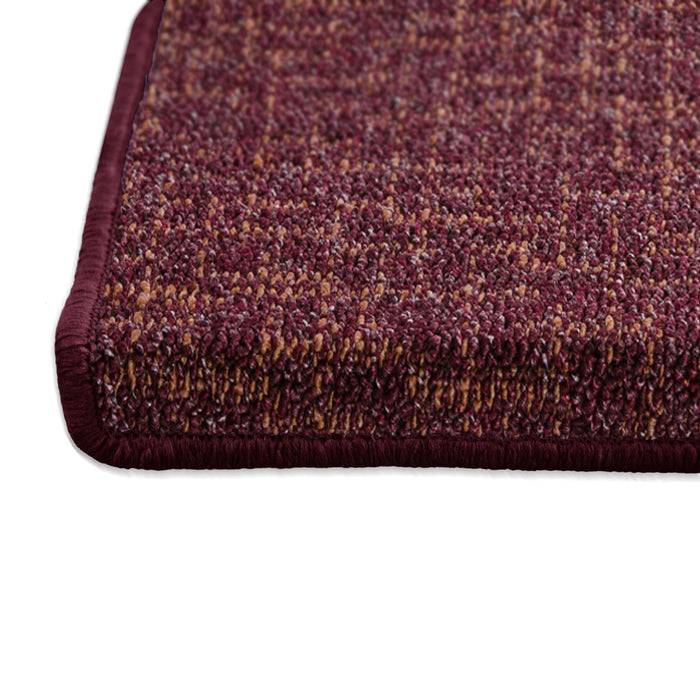 Ein rechteckiger, strukturierter kastanienbraun gefärbter Teppich mit dichtem Gewebe und durchgehender kastanienbrauner Borte, auf einer glatten, weißen Oberfläche platziert.