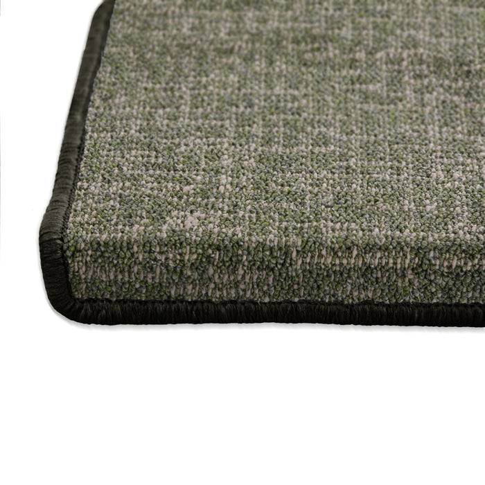 Nahaufnahme eines grünen Teppichmusters mit schwarzen Kanten, die Textur und Webmuster zeigend, geeignet für Inneneinrichtung oder Bodenbeläge.