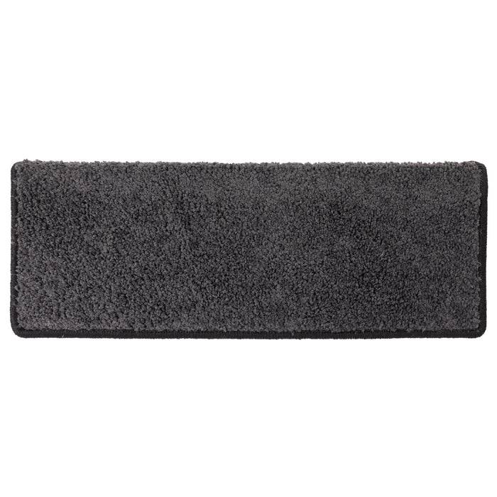 Eine rechteckige, dunkelgraue Fußmatte mit einer rauen Oberfläche, die zum Reinigen von Schuhen vor dem Betreten eines Gebäudes bestimmt ist.