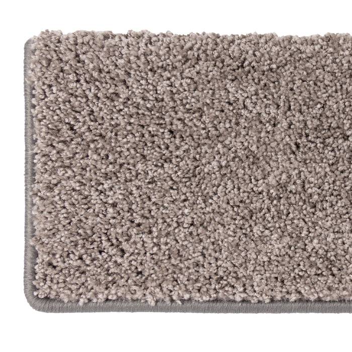 Ein rechteckiges beiges Teppichmuster mit strukturiertem Flor, das seine Farbe und Oberflächendetails zeigt.