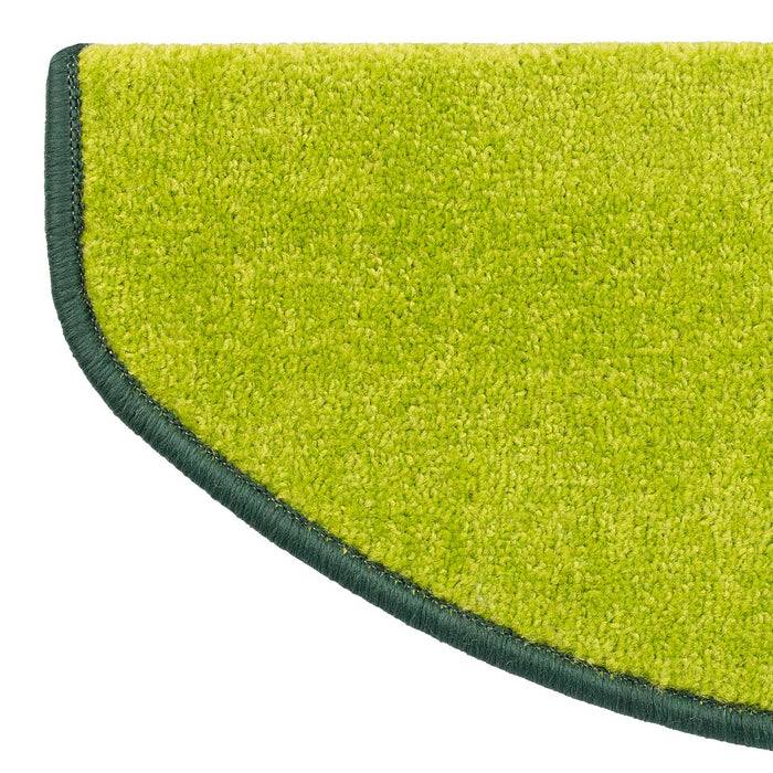 Ein halbkreisförmiger grüner Teppich mit dunklem Rand.